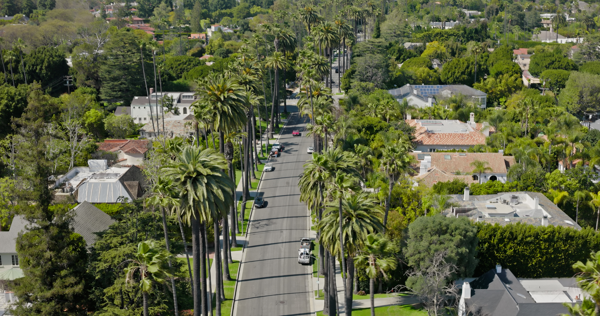 Aerial shot of residential street in Beverly Hills real estate on a sunny, Spring day in Los Angeles, California. Authorization was obtained from the FAA for this operation in restricted airspace.