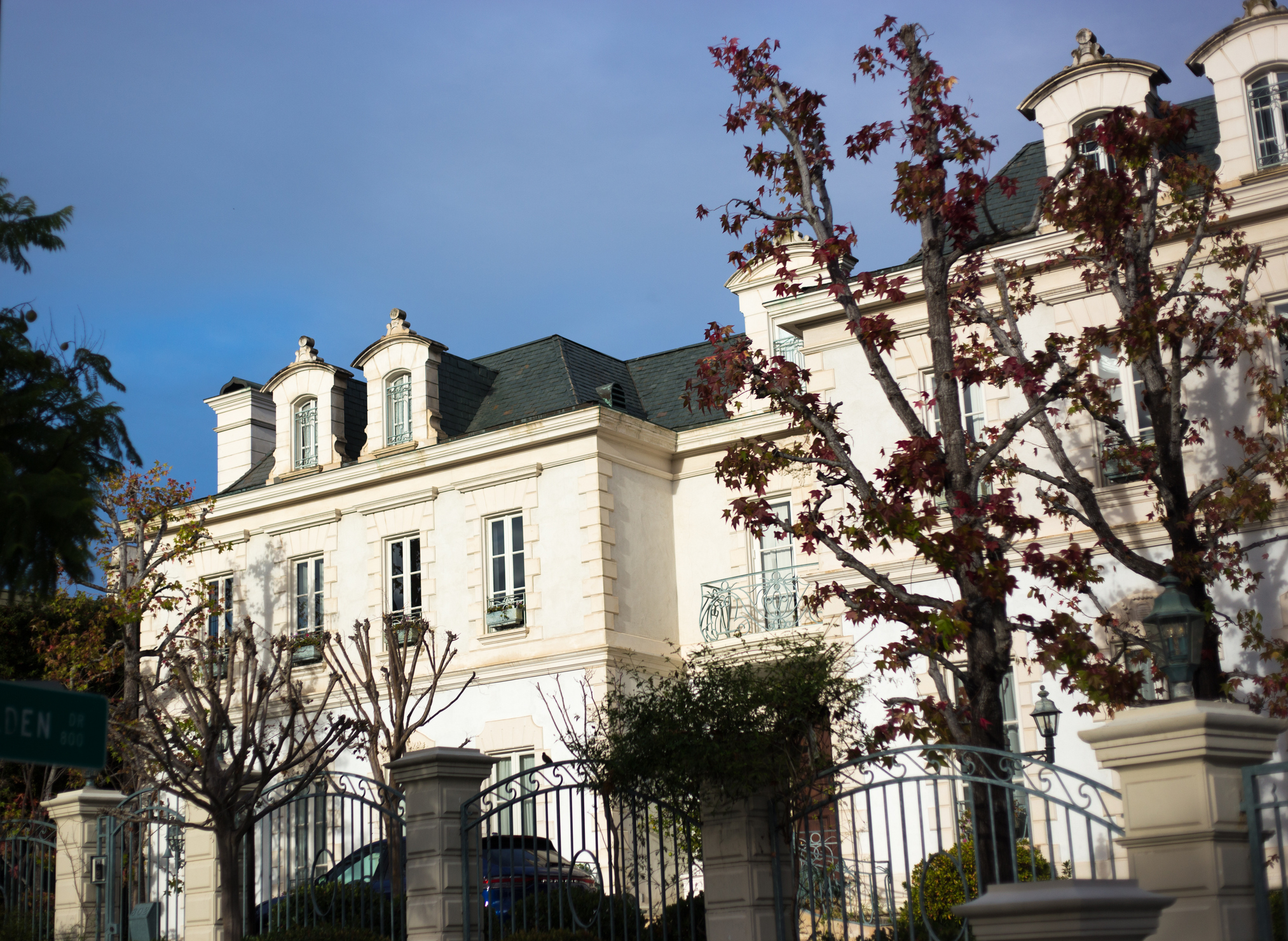 A luxurious white mansion with dormer windows in Beverly Hills.