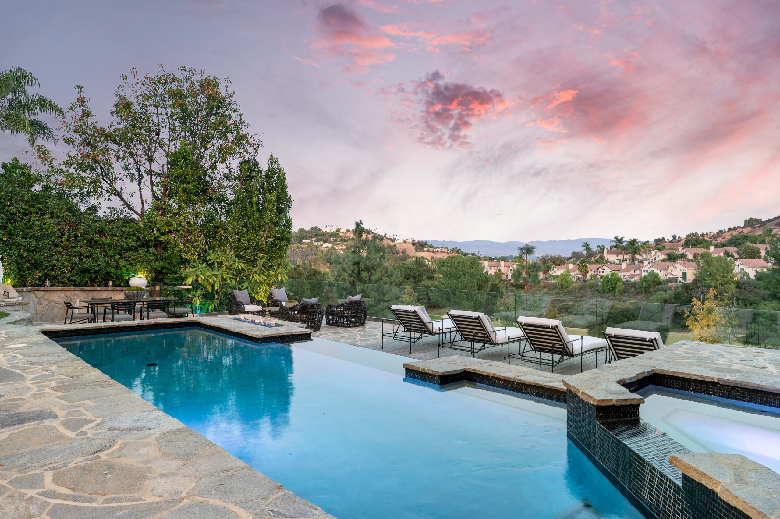 A swimming pool on a patio with a stunning sky backdrop