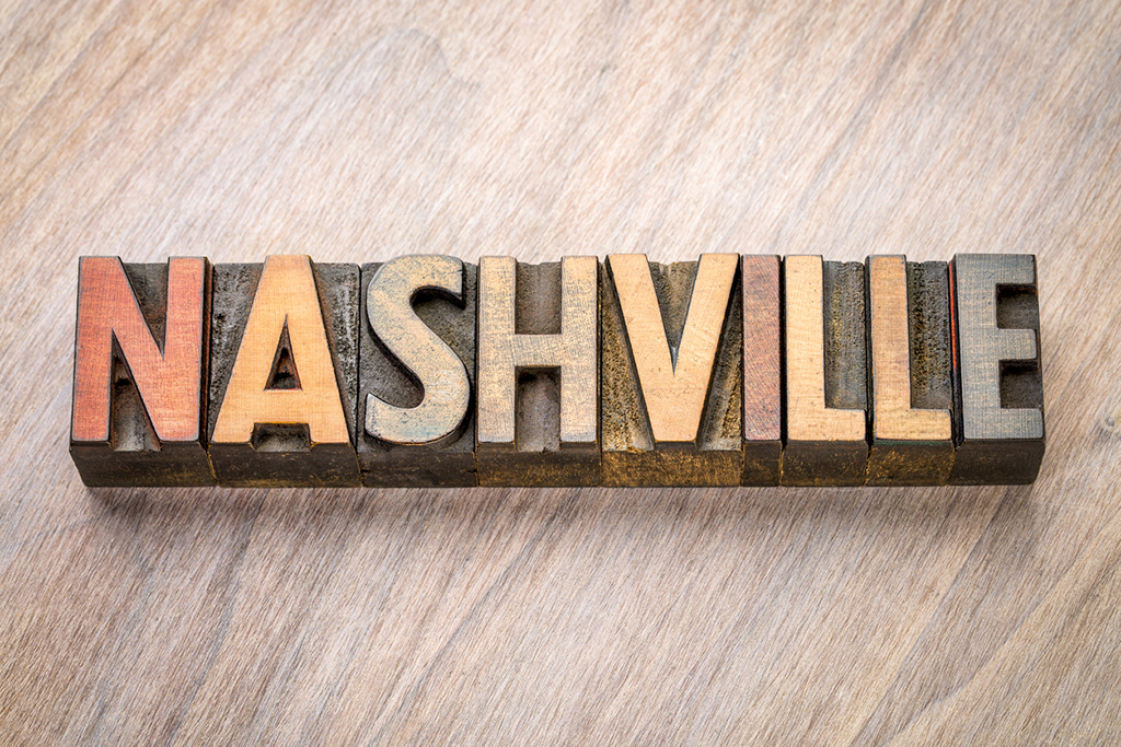 Nashville word abstract in vintage letterpress wood type against grained wooden background