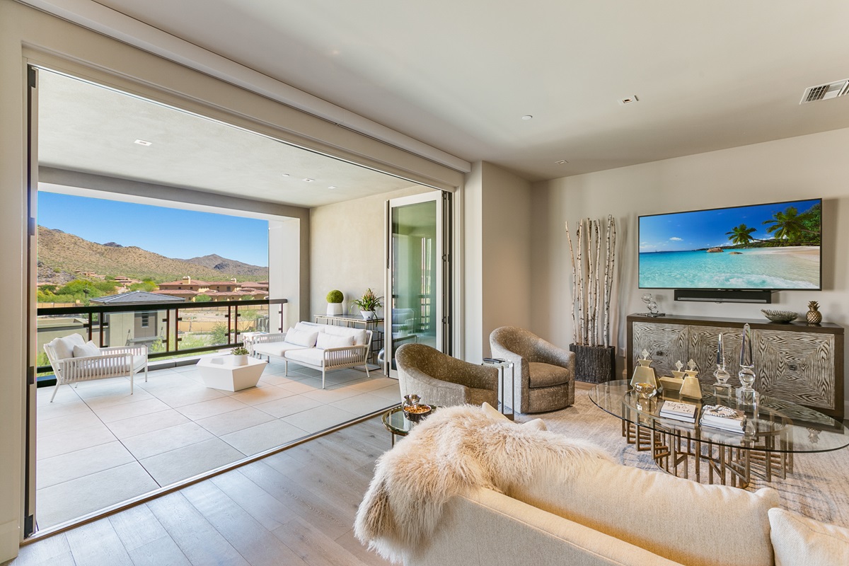 Elegant living room at Icon at Silverleaf with seamless indoor-outdoor design, plush seating, and mountain views.