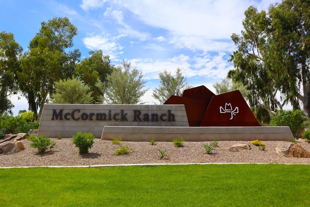 McCormick Ranch entrance sign in Scottsdale, surrounded by desert plants and trees under a clear sky.