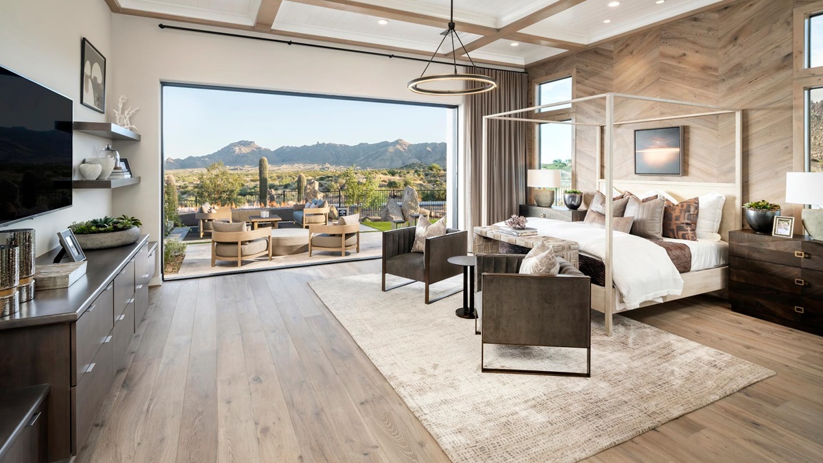 Modern bedroom opening to an outdoor seating area with desert landscape.
