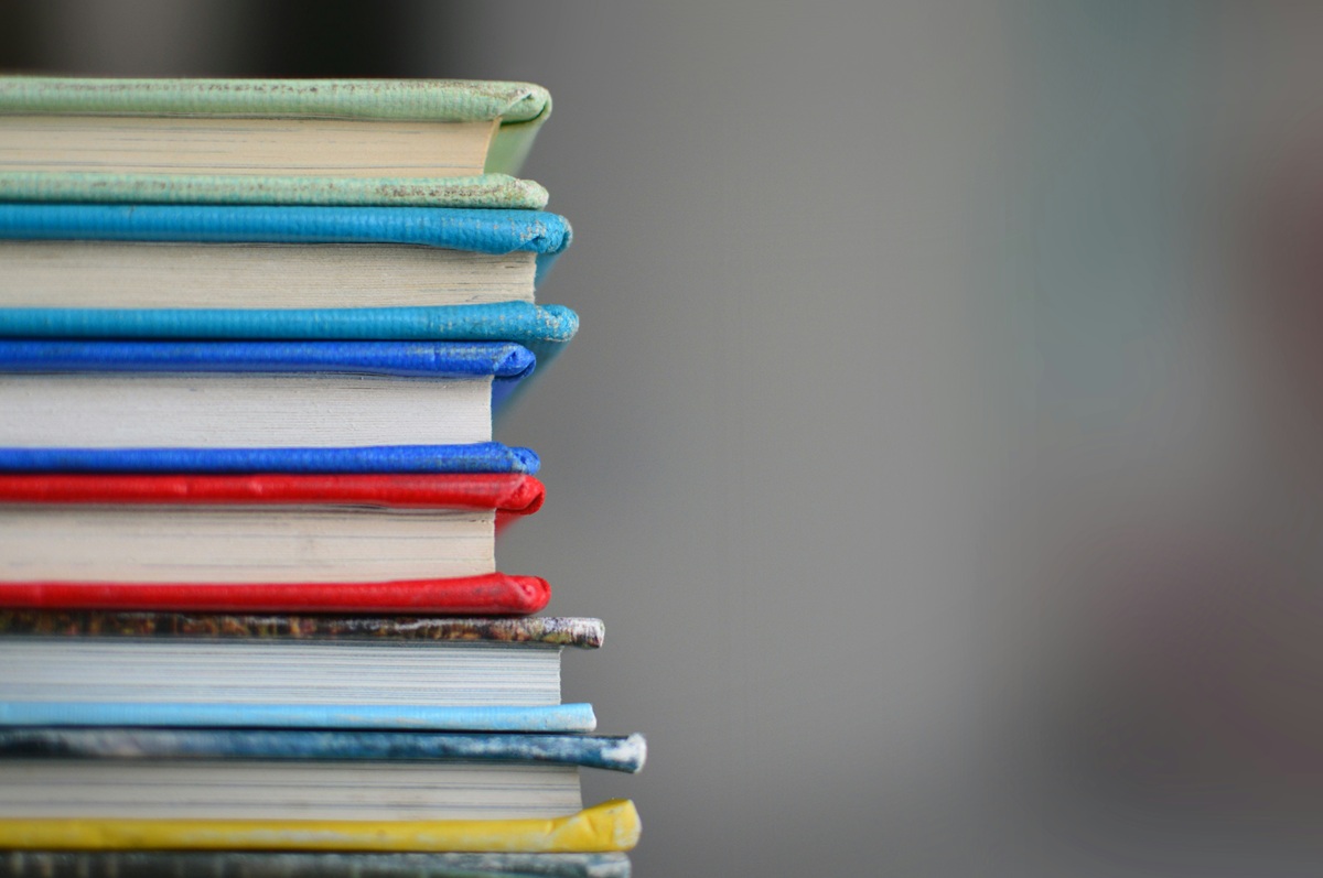 Stack of colorful books with a blurred background.