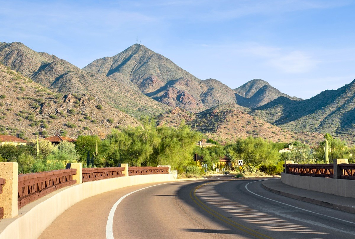 A scenic road winding through the desert with mountain views in Arizona.