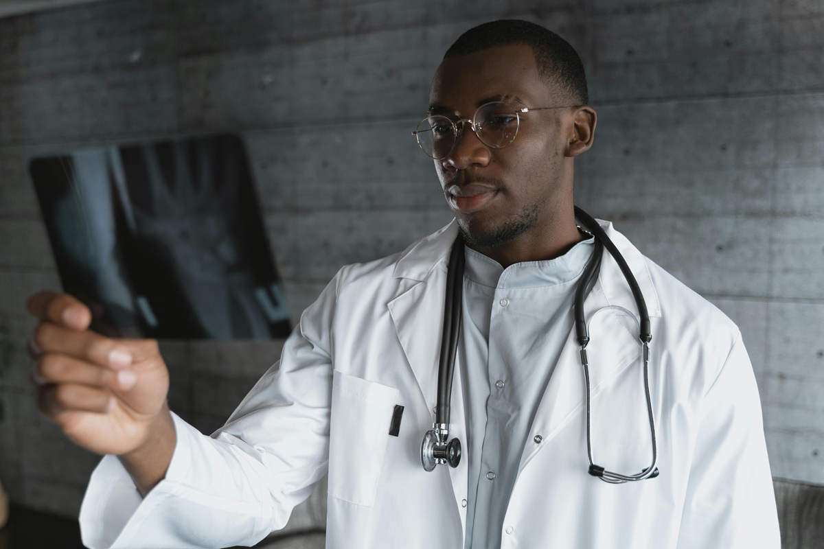 Doctor in a white lab coat examining an x-ray in a modern office.