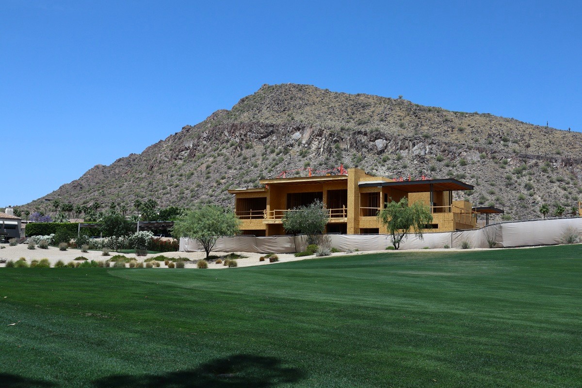 New home construction near a mountain with a golf course in the foreground.