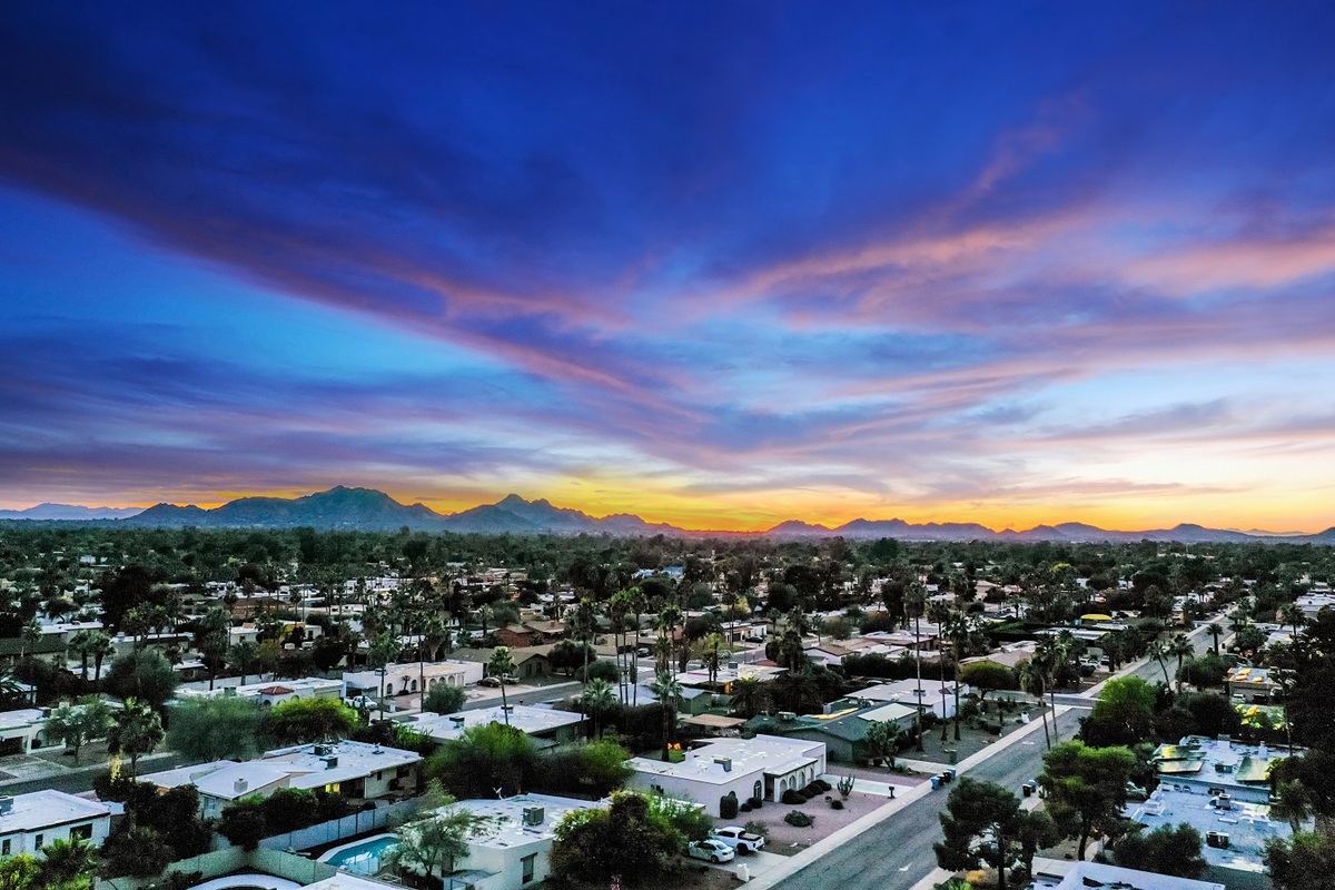 Vibrant sunset over Greater Phoenix, showcasing mountain views and cozy neighborhoods.
