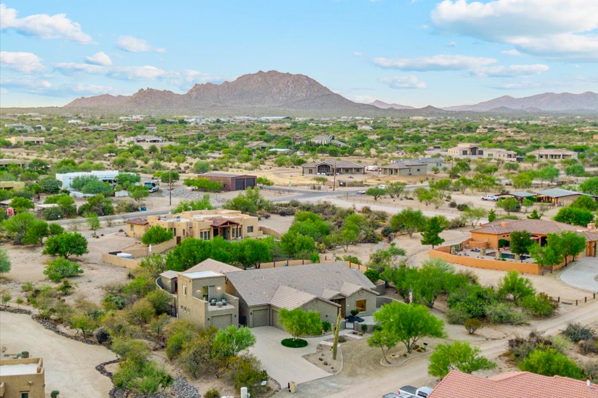 Aerial view of Greater Phoenix neighborhood with desert landscape and mountain backdrop.