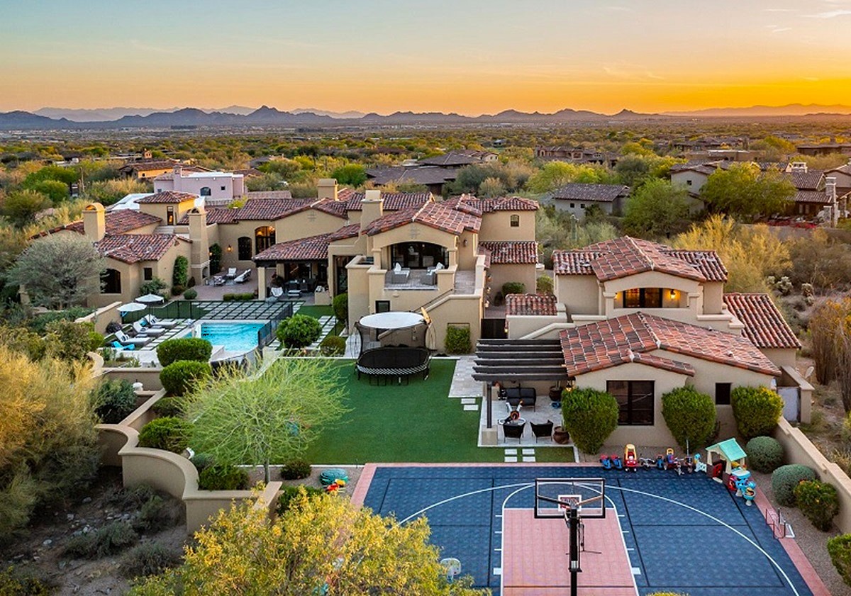 Expansive Arizona estate with a pool, basketball court, and desert landscape in the background.