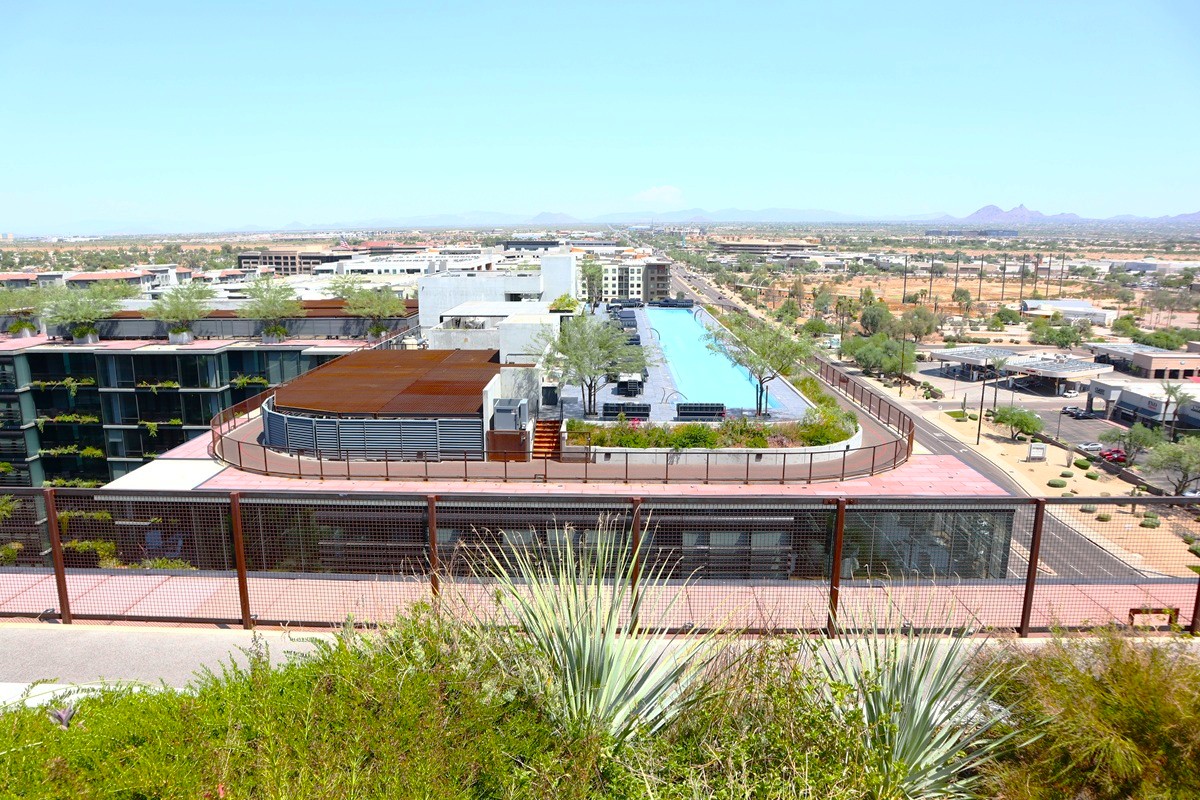 Rooftop view of Optima Kierland with pool, green spaces, and cityscape.