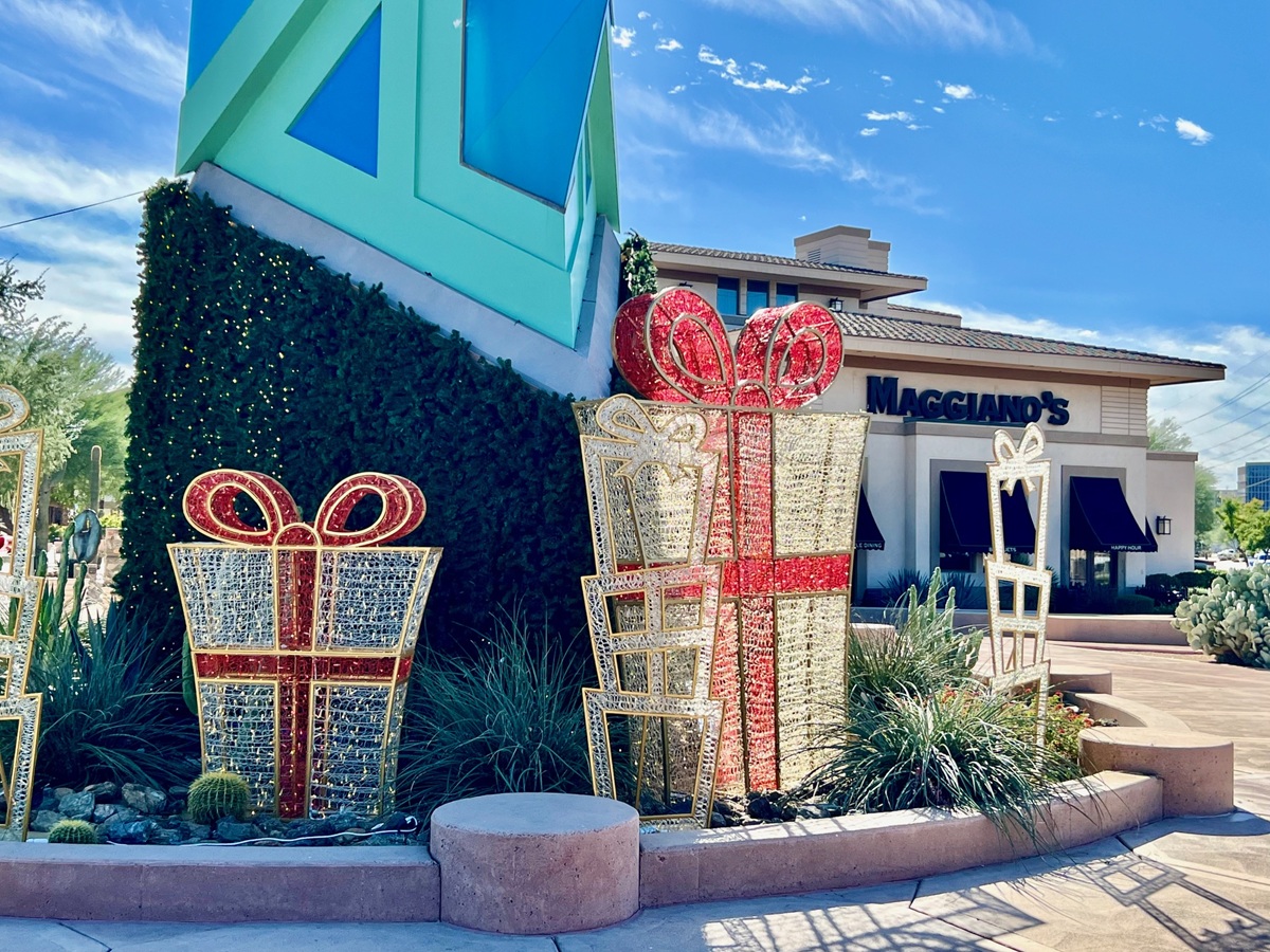 Large red and gold decorative gift boxes displayed near the Scottsdale Spire and Maggiano’s restaurant.