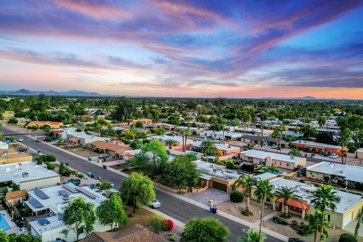 Aerial view of a serene residential area with classic Southwestern-style homes, showcasing Scottsdale’s suburban appeal and lush greenery amidst desert surroundings.