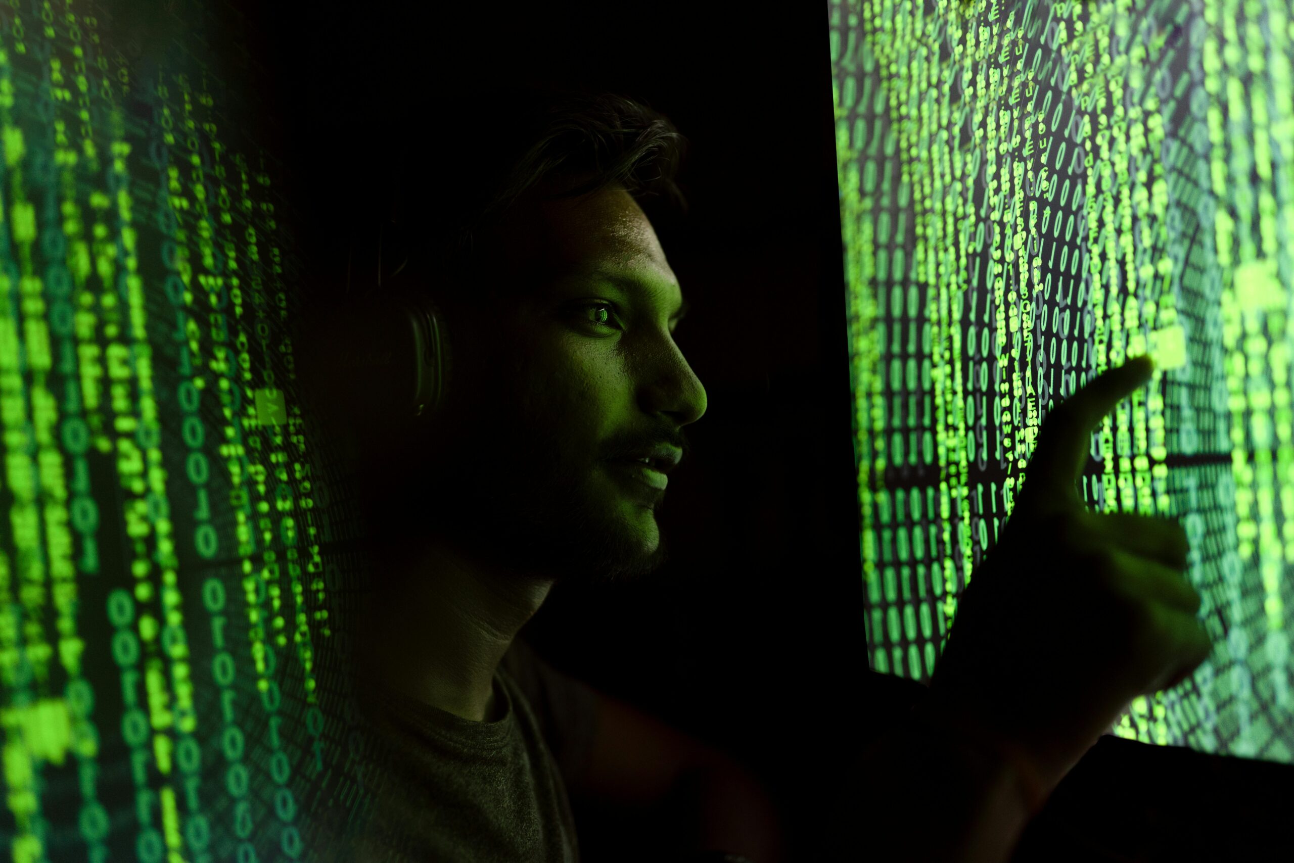 A person pointing to matrix-like code.
