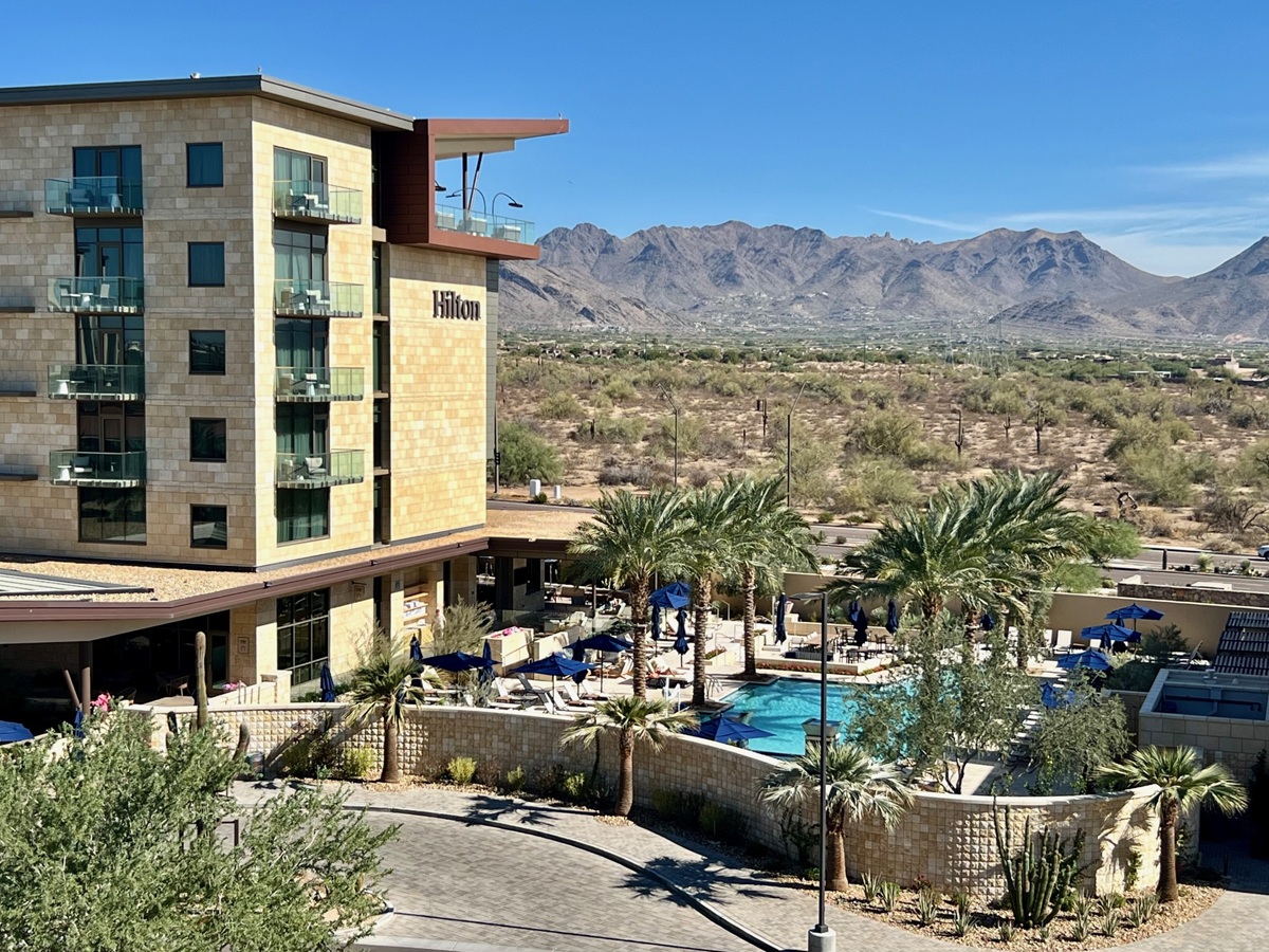 Hilton at Cavasson in North Scottsdale with a pool, palm trees, and mountains in the background.
