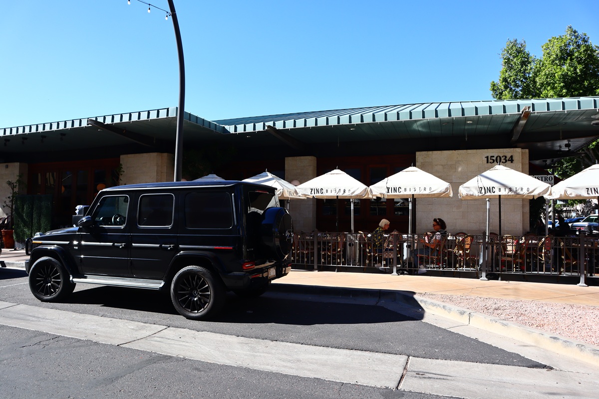 Black SUV parked outside Zinc Bistro in Scottsdale with outdoor dining umbrellas visible.