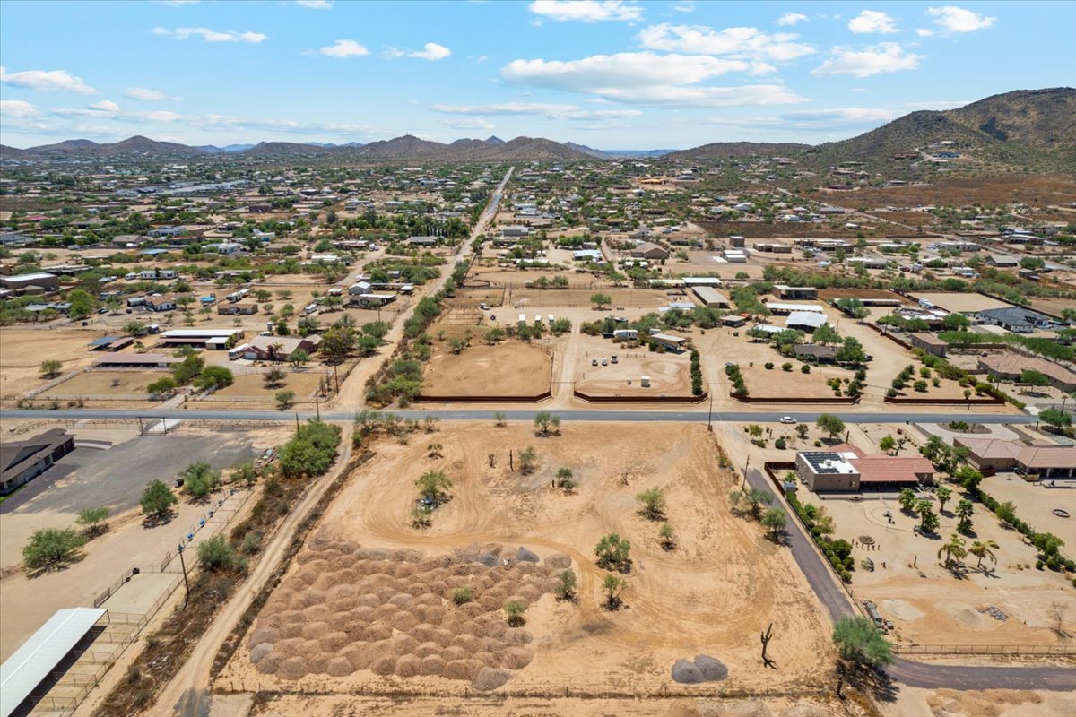 Blue skies with patchy clouds and a parcel of land seen from a drone.