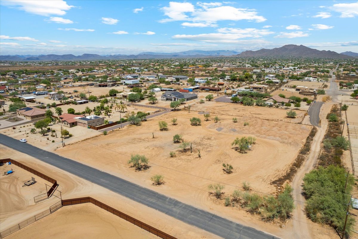 Blue skies with patchy clouds and a parcel of land seen from a drone.