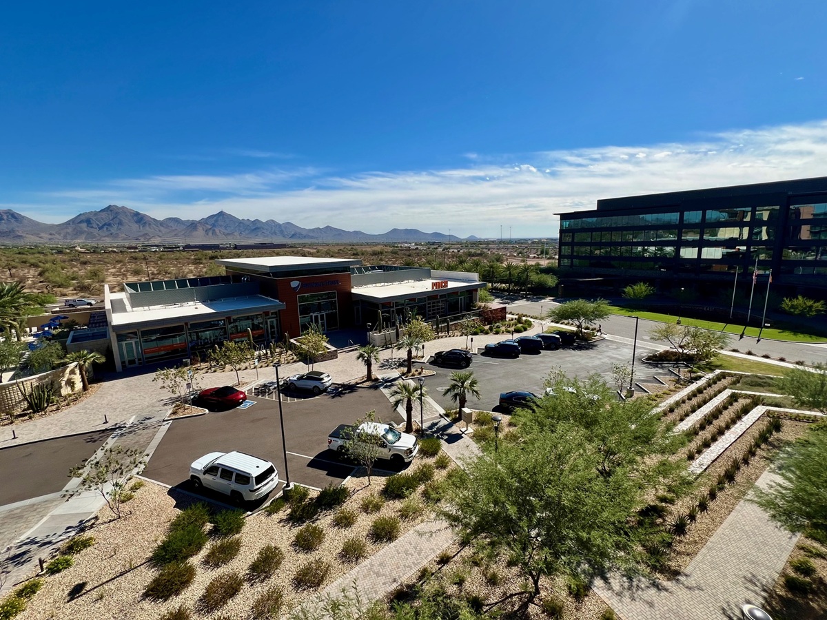 A commercial complex with mountain views, parking spaces, and clean surroundings, illustrating the city’s high-end retail and dining options paired with scenic backdrops.