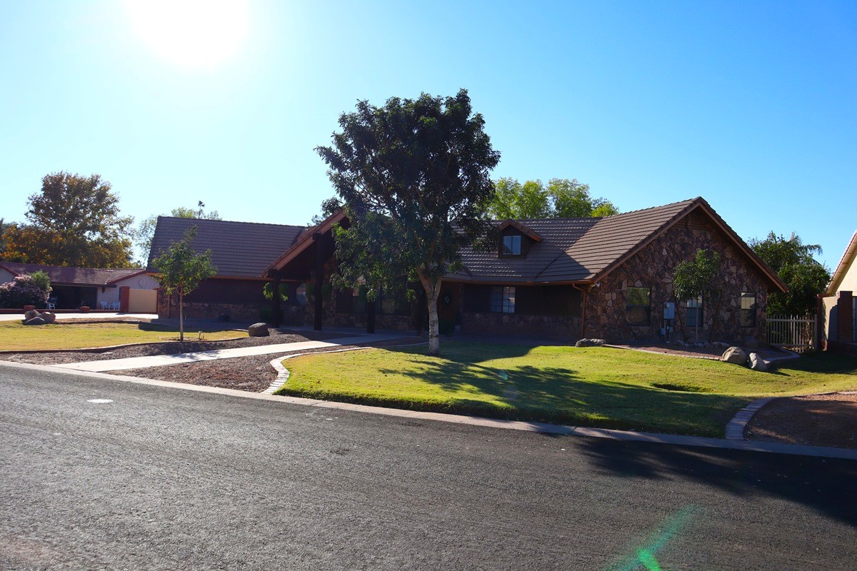 A single story home seen from the street during a blue sky sunny day.