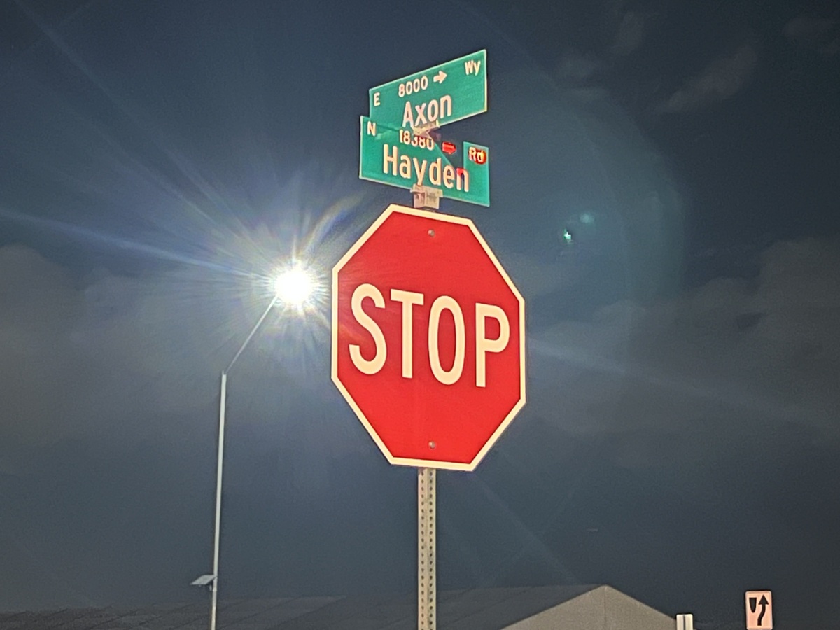 Photo of a two street signs saying Axon and Hayden as well as a stop sign below them.