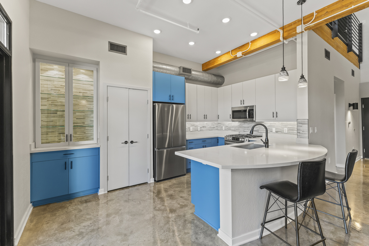 Modern kitchen with blue cabinets, stainless steel appliances.