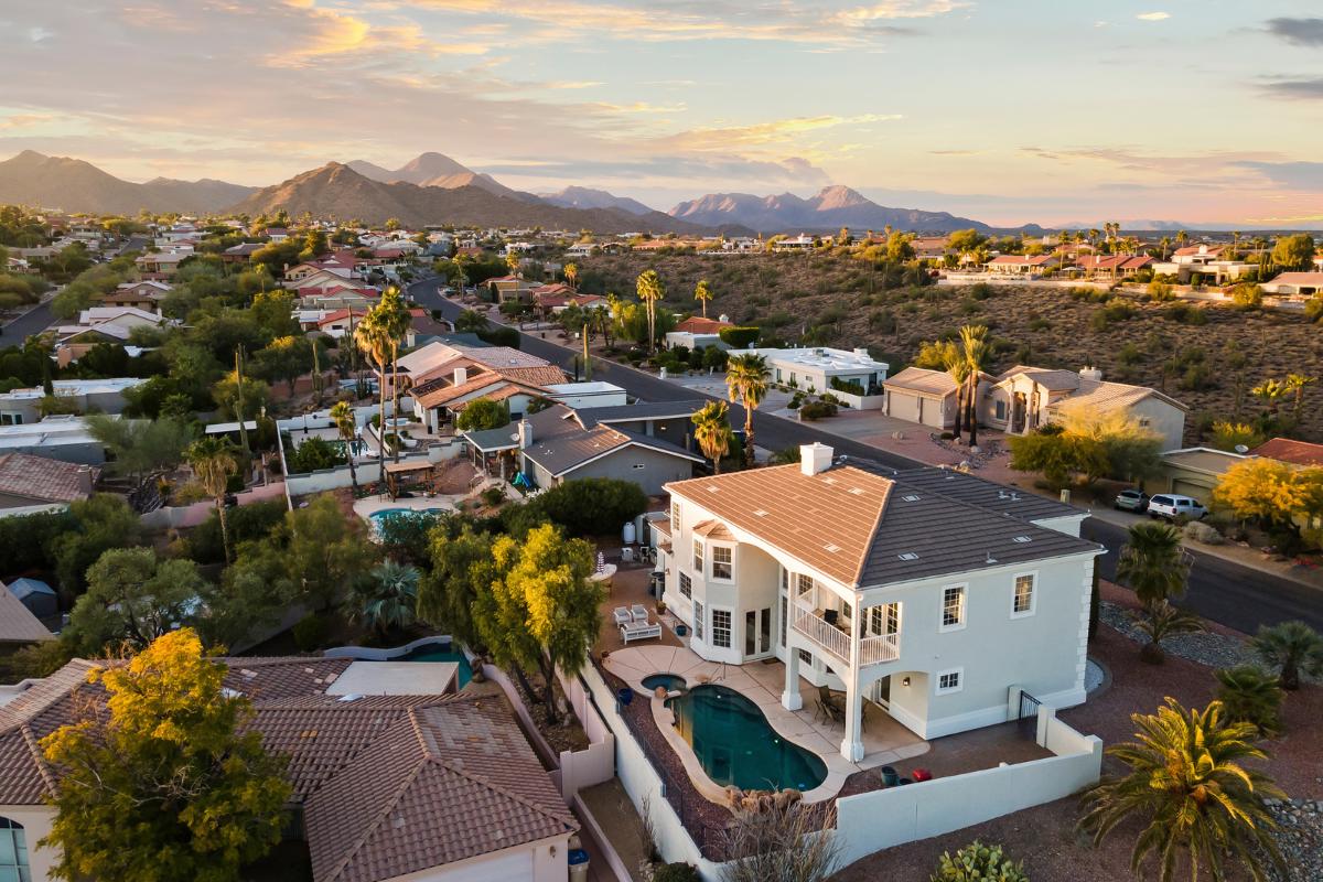 A top-down, angled drone shot of a luxury home and neighborhood in Fountain Hills.