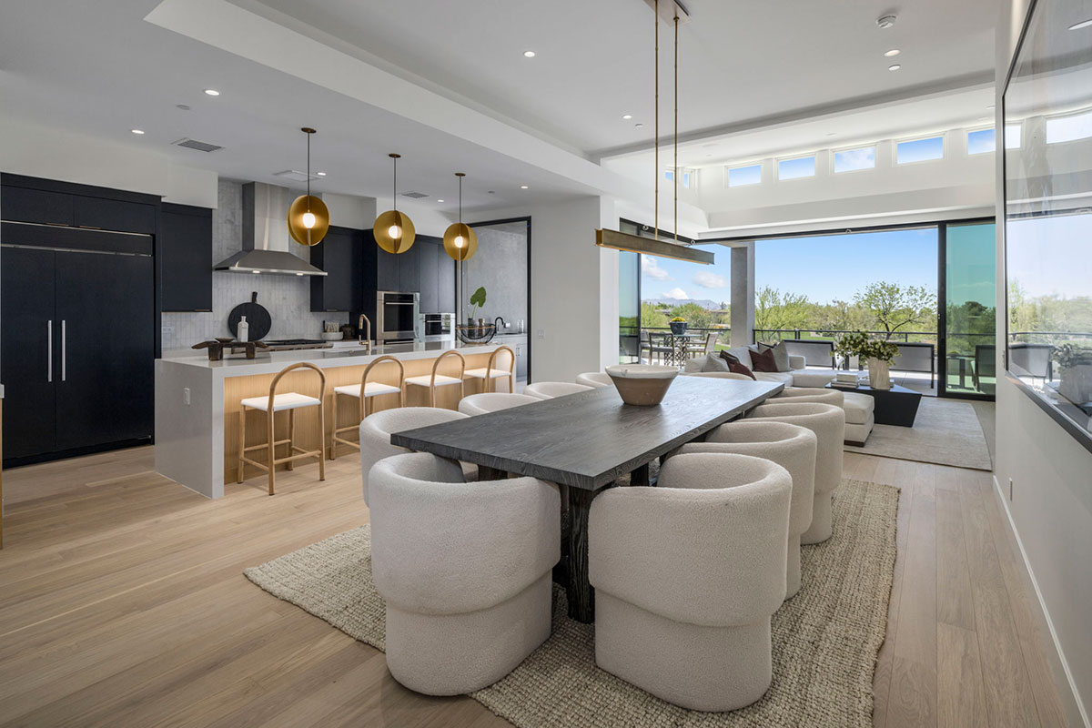 Open-concept kitchen and dining space with floor-to-ceiling windows and elegant modern decor.