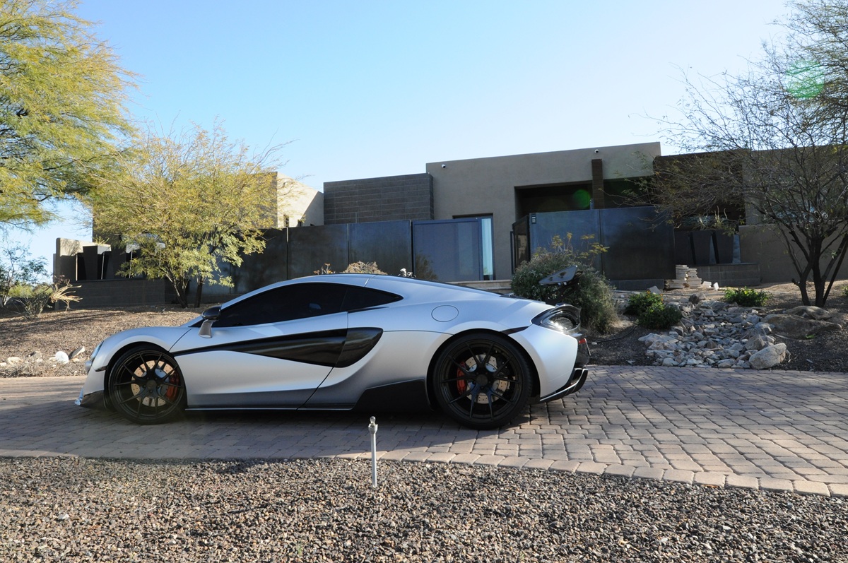 Sleek silver sports car parked in front of a modern home.