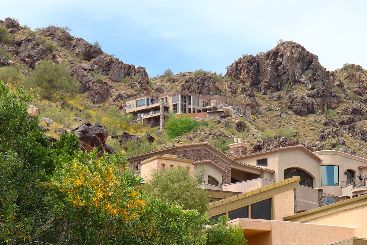 Elegant Paradise Valley mansion positioned dramatically against rugged desert cliffs.