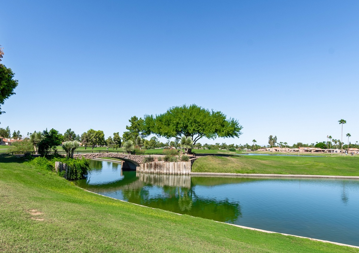 A green golf course with a small bridge and water feature in Scottsdale.