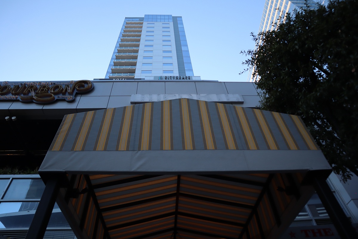 Looking up at a tall modern building with striped awning in downtown Phoenix.