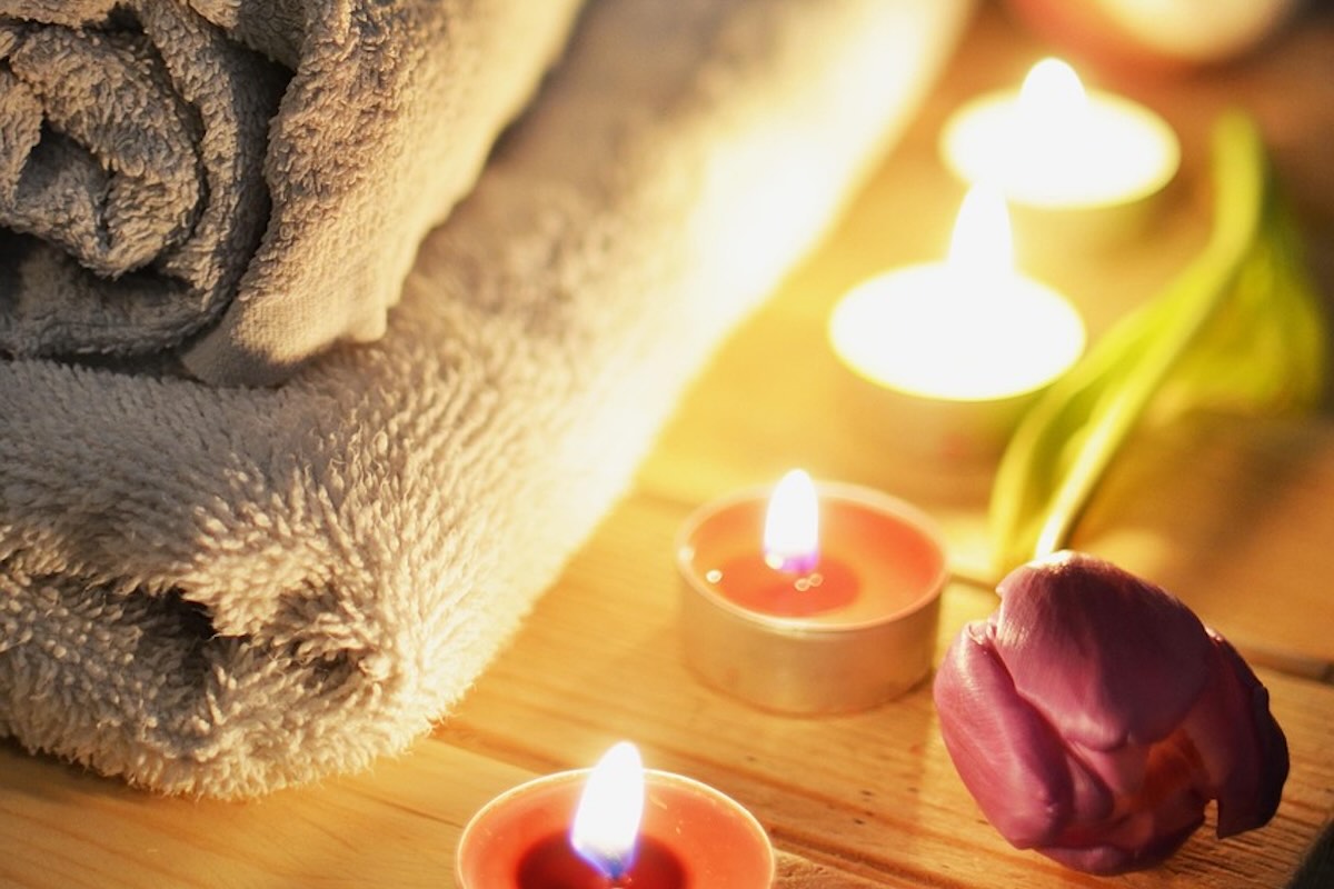 massage therapy towel, flower, and candles