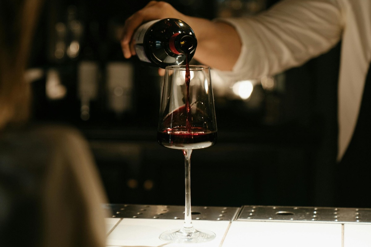 server pouring red wine