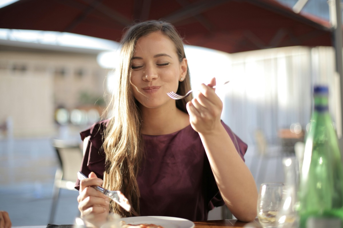 Woman eating food at an outdoor restaurant