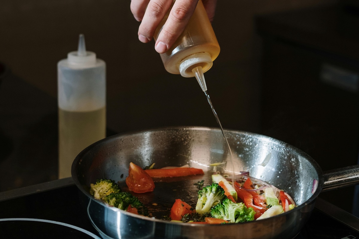 gourmet chef mixing oil into vegetables