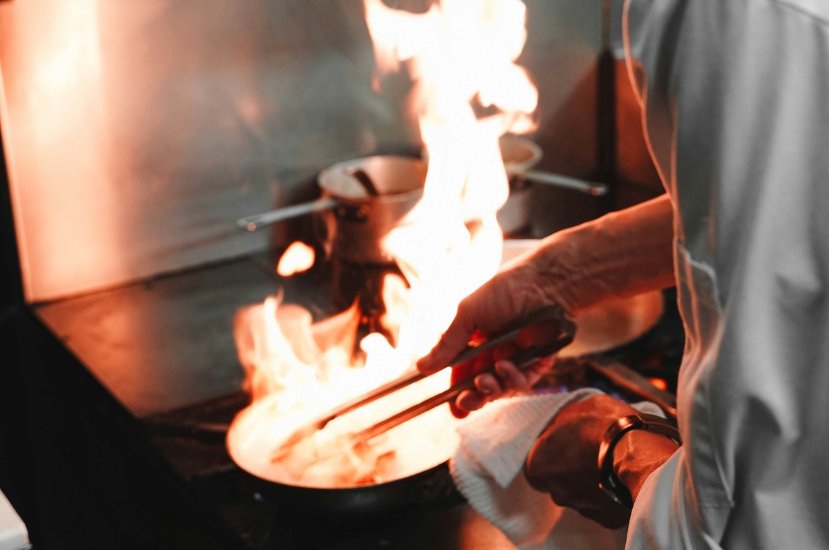 chef cooking with flames in high-end restaurant