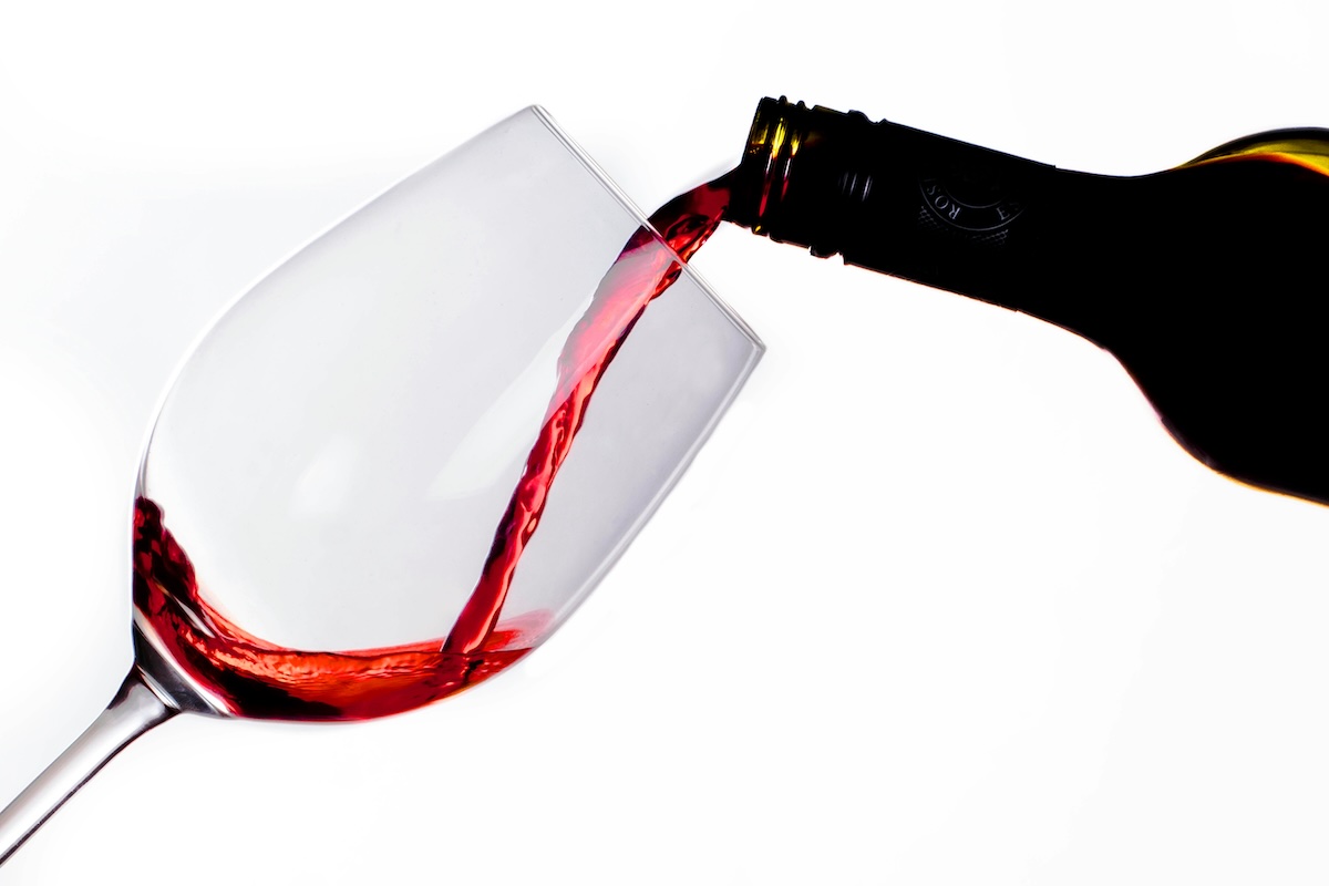 pouring red wine into wine glass