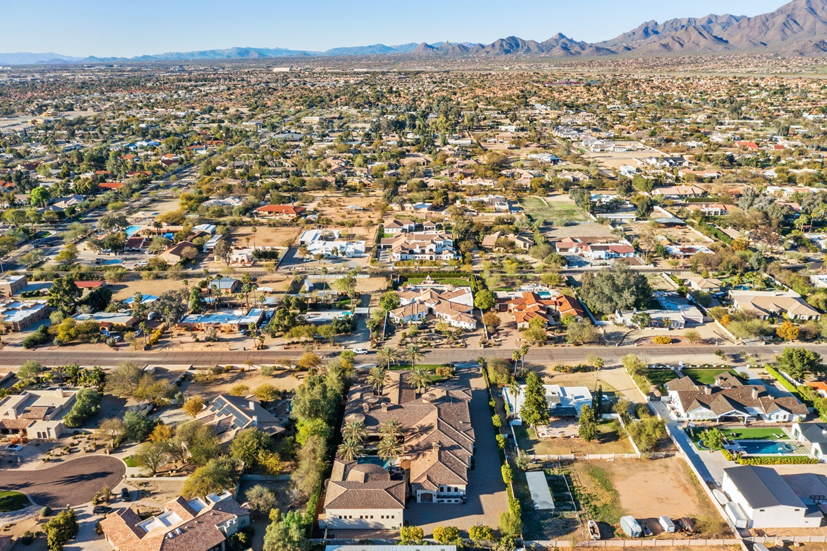 Expansive aerial view of Phoenix homes with mountains in the background.