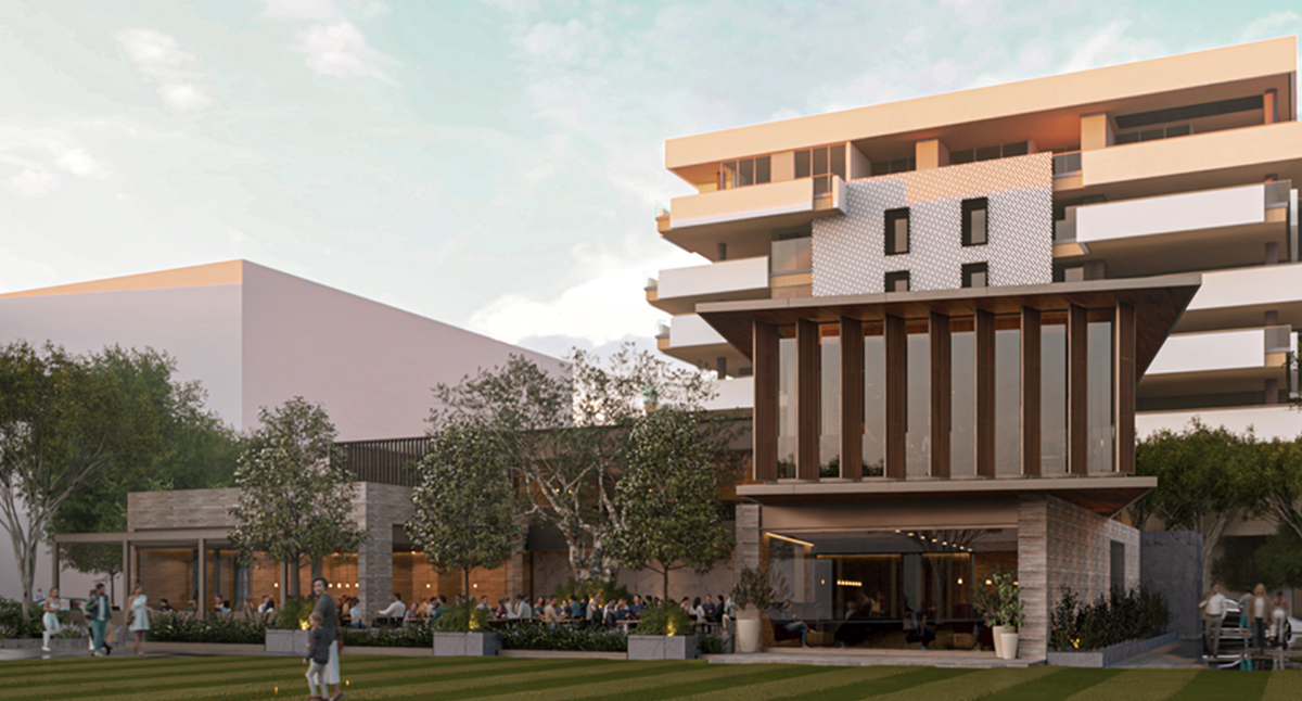 The Parque lawn facing a modern pavilion with tall windows and wood accents.