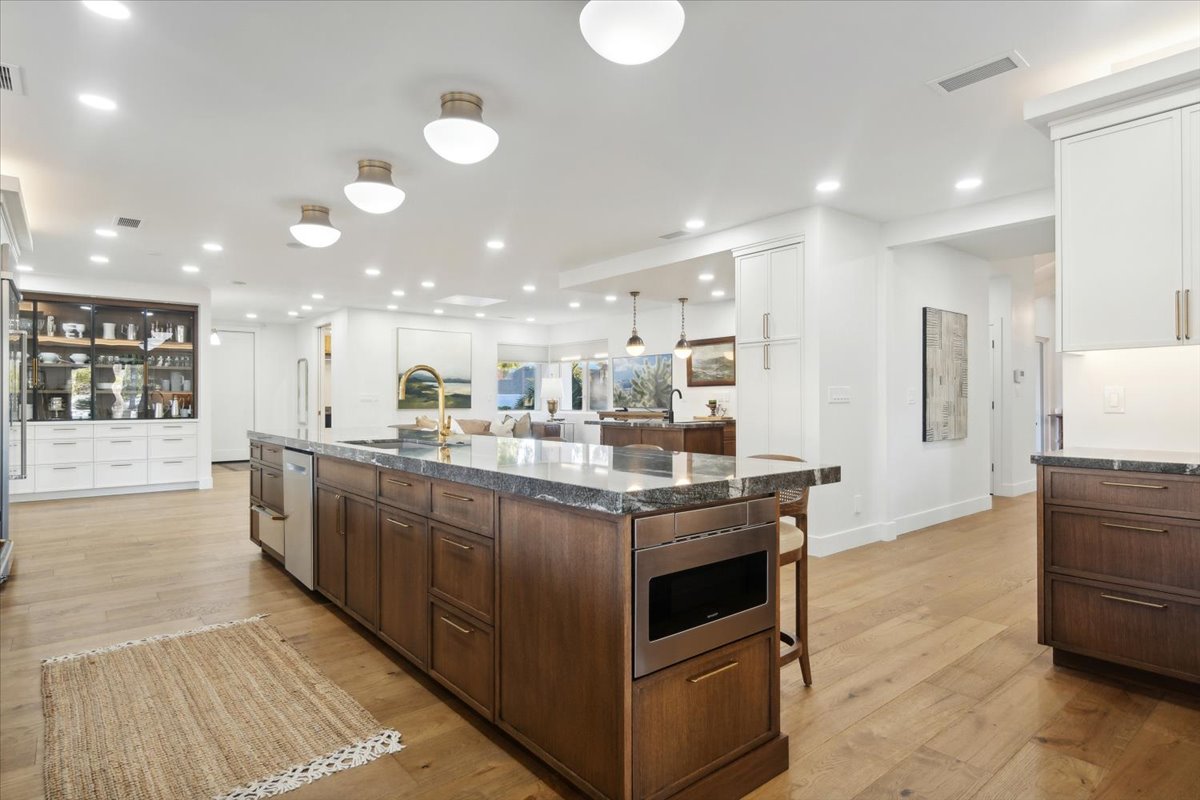 Spacious open-concept kitchen with large island, wood floors, and bright recessed lighting.