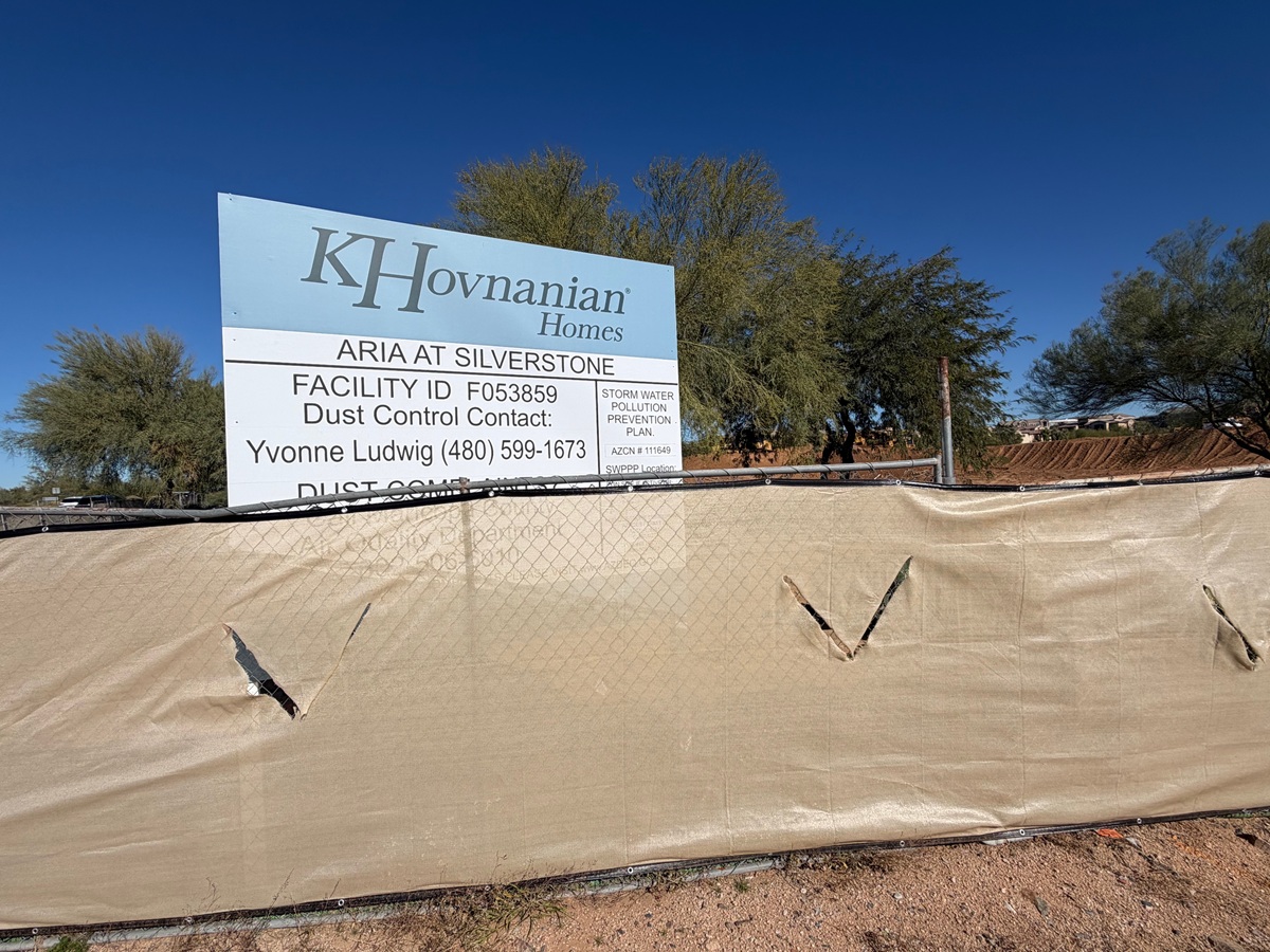 K. Hovnanian Homes sign for Aria at Silverstone posted behind a dust-control fence.