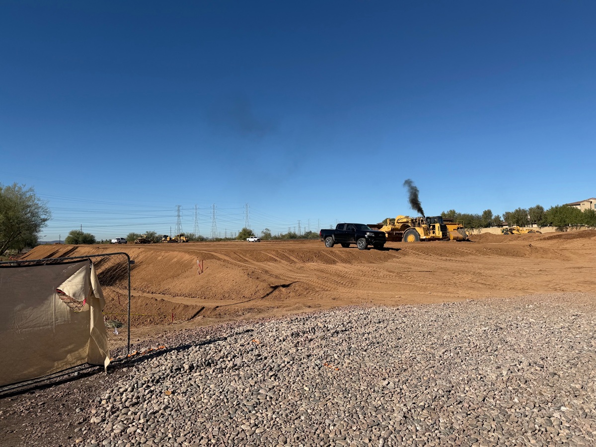 Wide view of mass grading with heavy equipment moving soil across the site.