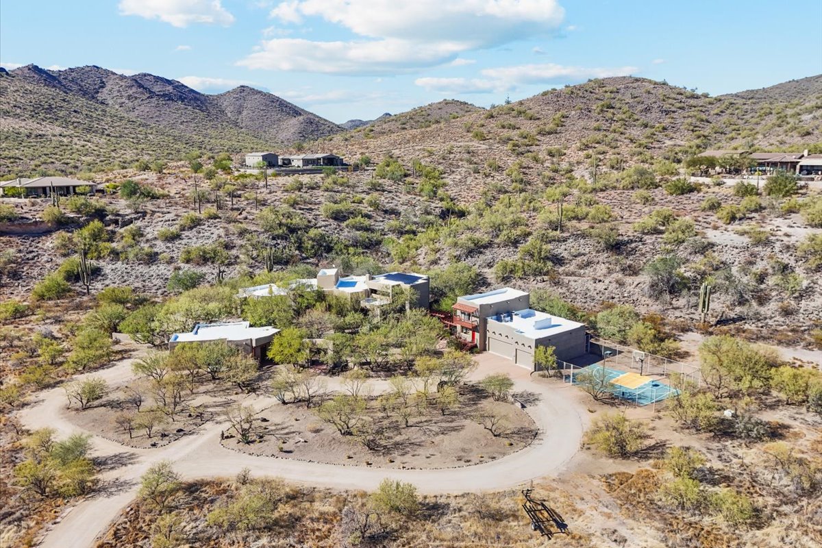 Desert home with flat roof surrounded by cacti and mountains