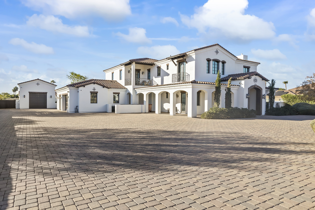 Luxury mediterranean style estate in Arizona with expansive paver driveway.