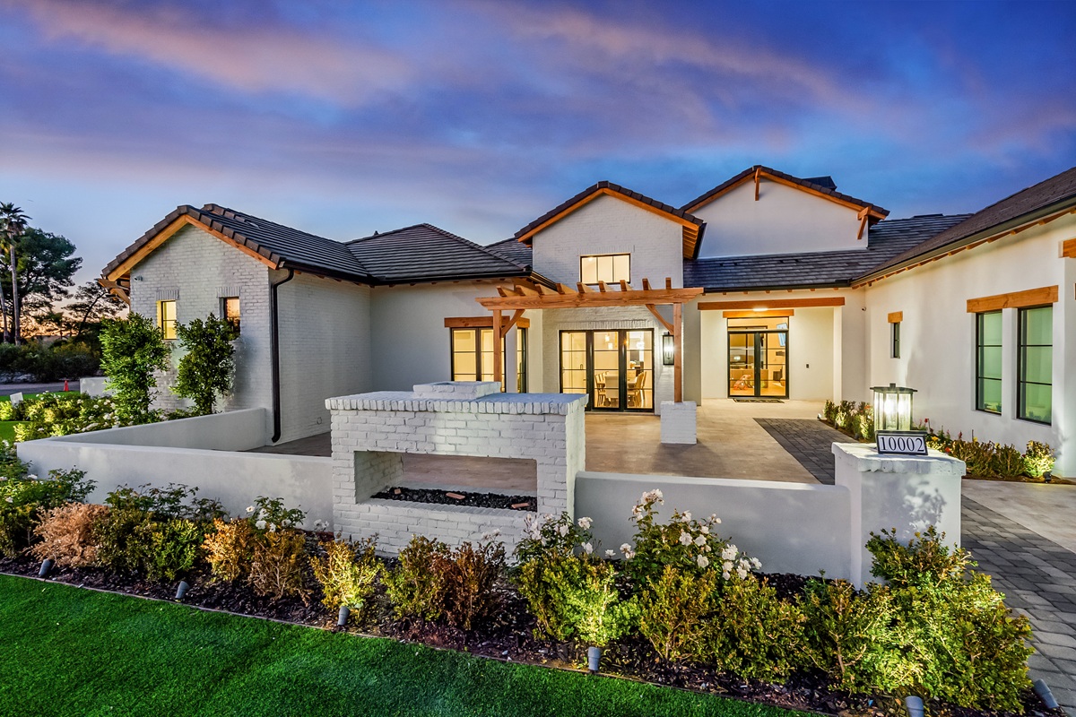 Modern luxury home with white brick exterior and landscaped courtyard at sunset in the Greater Phoenix area.