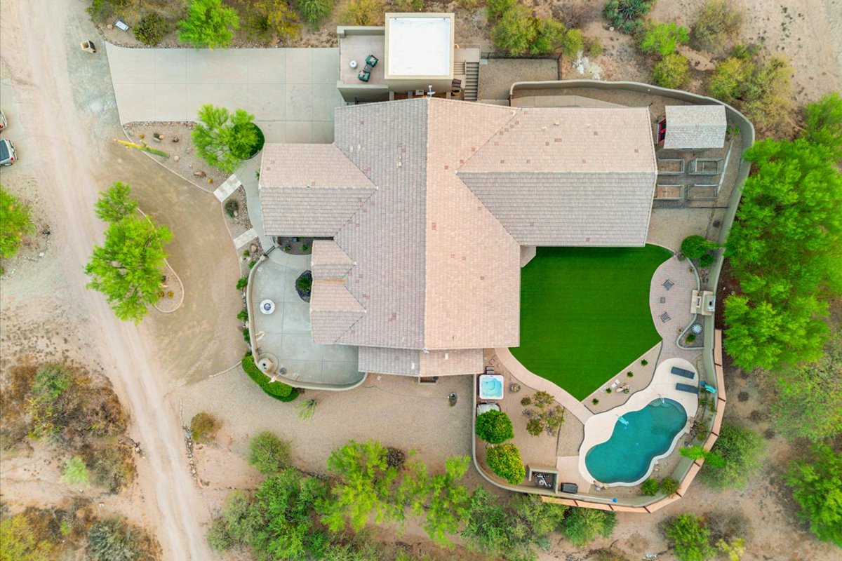 A photo of a desert property from above with a swimming pool, spa, & large lot.