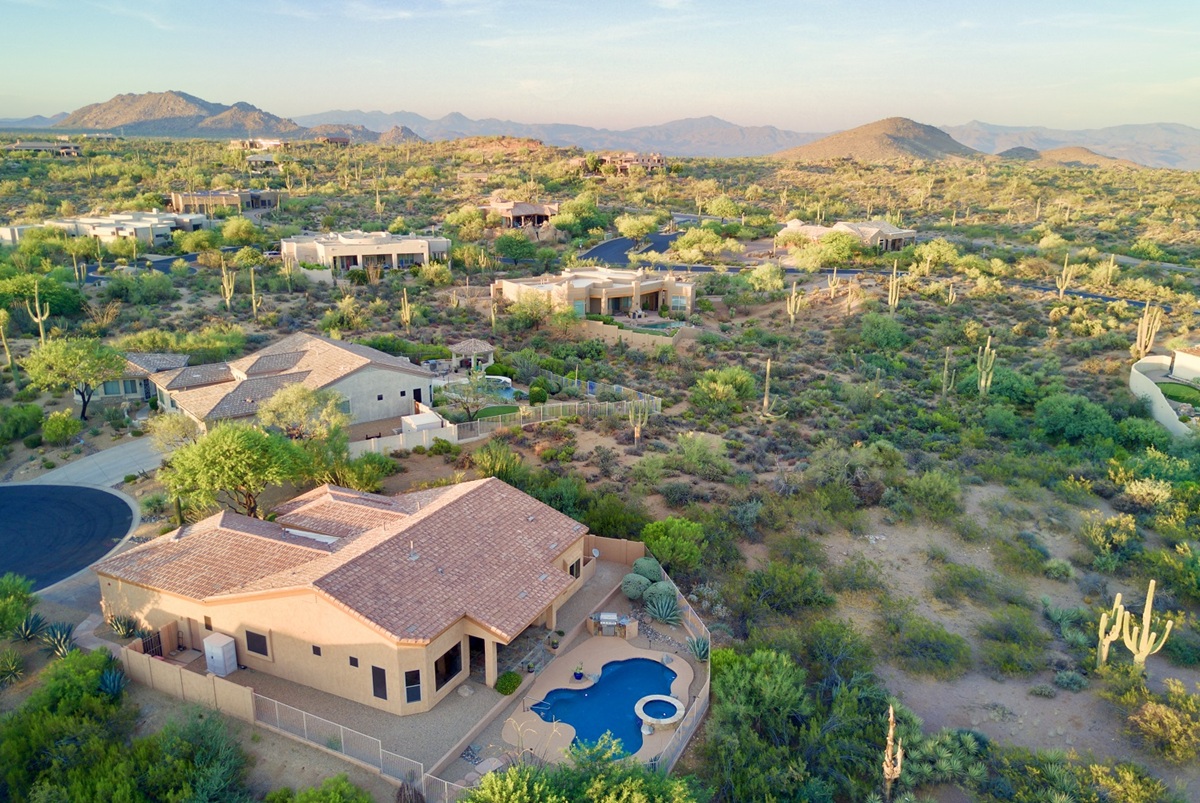 Aerial view of luxury desert homes at Troon in North Scottsdale with a backyard pool and mountain views.