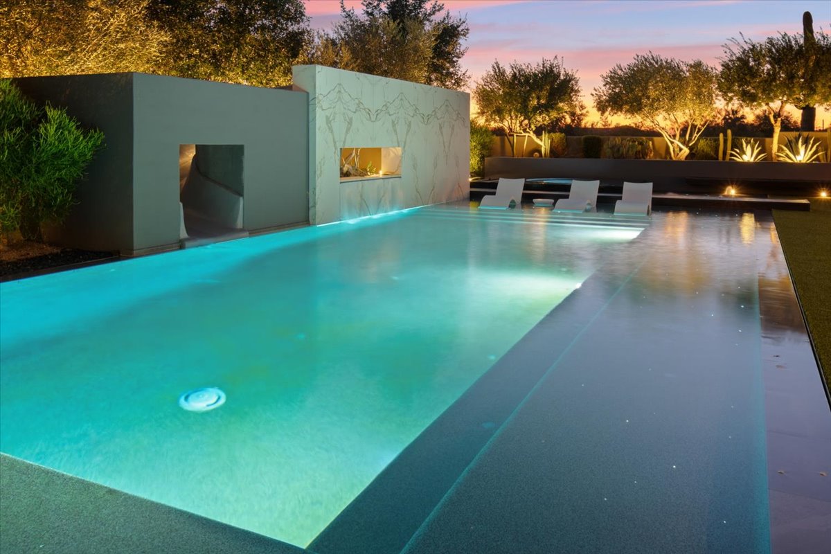 Illuminated luxury pool at sunset.