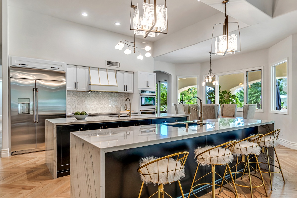 Luxury kitchen with large marble island and modern finishes.